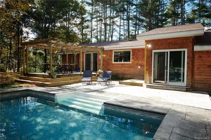 A Fresh Redesigned Mid Century Modern Ranch in Barryville, within a private woodland oasis PLUS yes!! a gorgeous in ground salt water pool. Open the front door and let the wow factor take over. The open main room with volume ceiling &cozy fireplace..designer chic concrete flooring with radiant heat. Every room has views of the backyard.. The heart of the home is an oversized kitchen that is so fun for creating the meals we all dream about.  Newly landscaped grounds featuring a rock garden, vibrant flowers, and sea grass (added this summer!) Hardwood flooring..Incredible bathrooms and large basement. There is a separate garage and space above awaiting your imagination. Book your private appointment to come and experience. Within 5 minutes to Barryville or Eldred for farmers markets and shopping .