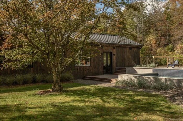 After winding through the lush surroundings of Fish Creek Rd, turn onto the newly built tree lined drive to your modern oasis in the woods of Saugerties. Clad in pine tar preserved pine and topped with a 24 gauge standing seam metal roof, your new home is sleek and sophisticated while still blending into the beautiful scenery that surrounds it. The original structure built in the 1800&rsquo;s and converted to a home in 1949 was treated with the Japanese technique of Shou Sugi Ban making the pine waterproof and seamlessly melding into the 1500 sq ft modern addition completed in 2024. Each Cardinal Glass Industries double pane window was placed strategically to offer maximum privacy and all day natural light while perfectly framing the mature Japanese Maple, Dogwood and Mimosa trees that fill the 1.5 acres of land. Designed for the ease of single floor living high end materials, designer fixtures and soaring ceilings reaching 16ft bring a sense of luxury. A combination of red and white oak floors run throughout the home while the bathrooms have terrazzo tile floors and lime-washed walls. Radiant heat is run through much of this flooring while 5 zones of mini splits offer efficient heating and cooling. On cozy winter nights the cast iron wood burning stove offers an additional heating source. The open floor plan is drenched in sunlight pouring in from an expansive wall-to-wall window in the kitchen with custom walnut inset cabinetry with paneled appliances and carrara marble countertops. The only thing to draw you out of this serene home is the outdoor entertaining space that rivals most resorts. A concrete construction saltwater pool adjacent to a Red Balau deck is just a few steps down from the 30ft x 12ft pavilion set atop a blue-stone patio. Water, gas and 100 amp electricity have already been run to the structure for you to create the outdoor kitchen and sauna of your dreams. With all the hard work done for you the only thing left for you to do is unpack and start living a life a world away.