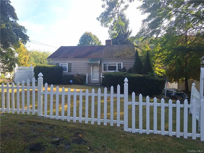 Welcome to your dream home! This charming 2-bedroom, 1-bath residence, complete with a white picket fence, is perfect for those seeking comfort and style. Step into the inviting front room featuring vaulted wood beams and a cozy wood-burning fireplace. The open floor plan seamlessly connects to the updated kitchen and a bright bonus sunroom, surrounded by large windows for added privacy and natural light. A hallway leads you to two cozy bedrooms and a beautifully renovated bathroom, all adorned with hardwood floors. Enjoy your private back deck, perfect for barbecues or sipping your morning coffee. Additional amenities include an attached one-car garage and convenient laundry in the basement. Ideally located just minutes from the Saw Mill Parkway, train, and bus, this home offers both tranquility and accessibility. Interested in a furnished option? We can discuss that! Schedule your showing today and make this charming house your new home!