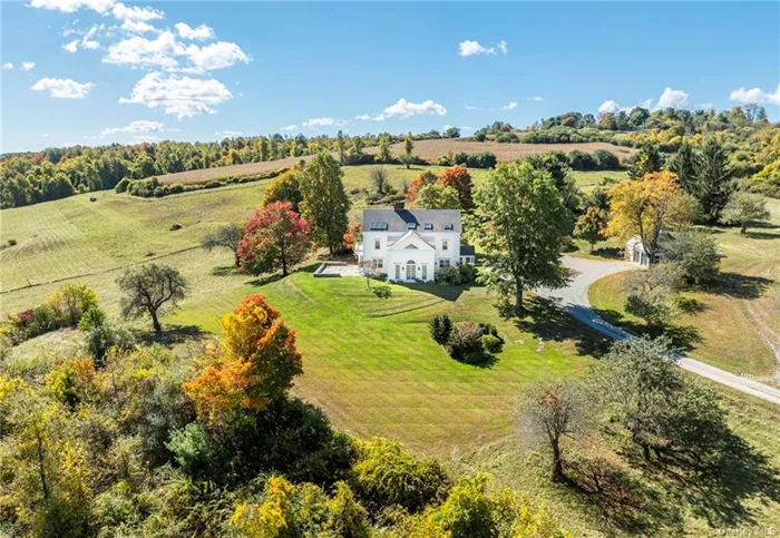 Ecstatic views from every window give Flanagan Hill its undeniable wow factor. A beautifully updated traditional home, Flanagan Hill enchants with its interior details and beautiful setting on 49 acres. At the end of a long, curving driveway, the property is perfectly private. The warmth of wide board floors, air and light from many windows, and the convenience of extensive storage on three floors are just some of the perks of Flanagan Hill. To the left of the wide entry hall a kitchen with butler&rsquo;s pantry, deep country sink, marble countertops and backsplash tiles, a five-burner stove, and a cozy sitting area with fireplace. To the right, a mud room with its own entrance and dog shower. This room, along with the library next door, are new additions to the home, less than 8 years old. In the firelit library, French doors offer an invitation to the sprawling lawn. The living room faces east through a large square bay window and two doors that open to a terrace rimmed with stone walls, which doubles the size of the living room for the purposes of warm weather entertainment. The living room&rsquo;s fireplace, bar with a spot for wine fridge, and spacious dimensions make it as perfect for gatherings as for quiet evenings. The soaring, two story dining room opens to a gently sloping lawn and views for miles to the north and east. French doors and floor to ceiling windows, and a fan light over windows that reach into the cathedral ceiling guarantee great light as well as views of the stars as evening falls. Upstairs, a broad landing opens to two guest rooms with a shared hall bath and the primary suite with balcony, large closet/dressing room, and a clawfoot soaking tub as well as a marble-lined walk-in shower. On the third floor, there are three rooms. Most significant is an enormous room ideal for an office, yoga/meditation studio, or playroom that features two walls lined with window seats, skylights, and a triangular picture window with long views to the east. A second room on the third floor has a similar window facing west, and another small room between them with a large dormer skylight. On the property are exquisitely curated perennial gardens behind winding stone walls, a pond with dock, and two-car garage. Also, a big, red, recently built barn with loft offers many possibilities, from housing livestock to creating guest housing or entertainment space. 24 hour advance notice required for accompanied showings.