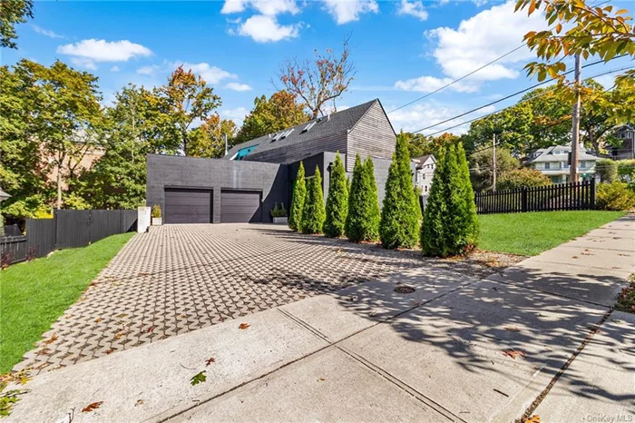 Architectural masterpiece at 2 Woodland Pl, White Plains, this custom-built home by Stuart Shanks Architecture and b*space studio combines sleek modern design with vibrant elements. The striking exterior, with unfinished wood rain screens and exposed concrete, features bold volumes stacked with dynamic voids that flood the home with natural light. Inside, high-end finishes define the open-concept living space. The kitchen boasts quartz countertops, and custom cabinetry, while the spa-like bathrooms feature in-floor heating. Splashes of color throughout the home reflect the avant-garde approach that has been recognized in designboom. Every detail of this home, from the placement of furniture to the creative use of space, is thoughtfully crafted with an &rsquo;inside out&rsquo; design concept. Outside, the seamless flow between interior and exterior spaces offers a unique connection to the environment, with open patios on the second floor blending with the bedrooms. The front entrance, framed by glass, creates an inviting indoor-outdoor dining and living area. Located in a commuter-friendly neighborhood with easy access to transit, this home is both a visual and functional gem. A rare opportunity to own a distinctive architectural statement in a vibrant suburban setting.