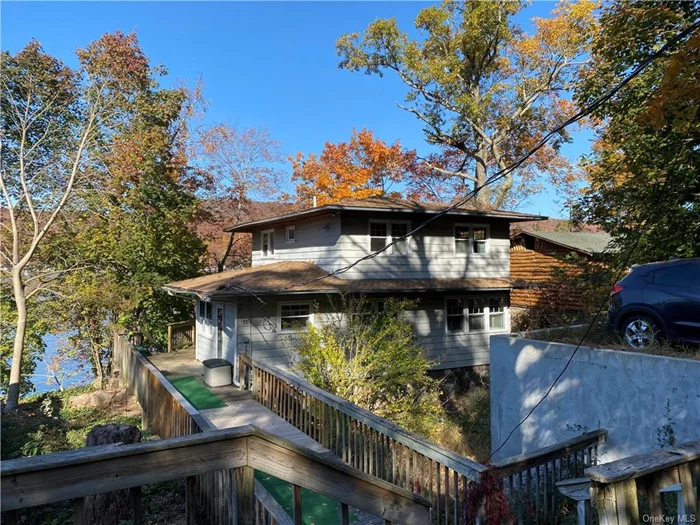 JUST LISTED! LAKEFRONT LOCATION IN THE PRESTIGIOUS COMMUNITY OF FOREST KNOLLS ON THE EAST SHORE OF GREENWOOD LAKE! TWO STORY OFFERS AN EAT IN KITCHEN W/ISLAND, TILED FLOOR, LOTS OF WINDOWS! SPACIOUS LIVING/DINING ROOM HAS A STONE FIREPLACE AND VIEWS OF THE LAKE, RECESSED LIGHTING, 1ST FLOOR DEN W/PLENTY OF LIGHT, 1/2 BATH HAS WASHER/DRYER FOR EASY ACCESS. SECOND LEVEL OFFERS MASTER BEDROOM WITH WALK IN CLOSET PLUS SLIDER TO ITS OWN BALCONY OVERLOOKING THE LAKE! SECOND BEDROOM, AND FULL BATH. TWO TIERED DECKING ALLOWS FOR GREAT ENTERTAINING. DOCK AT YOUR OWN DOOR! COVERED BOAT LIFT! OUTDOOR DINING AREA W/AWNING! STEPS TO DRIVEWAY AND PARKING AREA. FOREST KNOLLS BOASTS A BEAUTIFUL BEACH RIGHT DOWN THE ROAD. YOU WILL ENJOY MAKING THIS HOME YOUR OWN! COMMUTER ROADWAYS & NYC BUS NEARBY. VERY PEACEFUL SETTING YEAR ROUND! NEW OWNER MUST JOIN FOREST KNOLLS ASSOCIATION IF THEY WANT BEACH ACCESS.