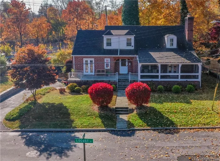 Nestled in the sought-after Orchard Hill neighborhood of Greenburgh, Westchester County, this enchanting 1936 Brick Tudor-Style Colonial home blends classic elegance with modern comforts. Its curb appeal features meticulously manicured shrubs & vibrant plantings. The front entrance leads to a spacious open platform. A charming summer porch is perfect for morning coffees. Inside, the extra-large living room exudes warmth with a striking floor-to-ceiling stone wood-burning fireplace. Vaulted wood-beam ceilings enhance the ambiance, with French doors connecting to the summer porch. Adjacent, a primary bedroom offers a full ADA-compliant bathroom accessible from both the primary & second bedrooms. The EIK has a generous granite island, stainless appliances, door to 2nd porch. UL offers 2nd Primary Bdrm, 2 more Bdrms, Full bath. The LL includes a 2nd LR, 2nd Fireplace, Storage, Laundry space. 2 car garage with extra-long driveway. Updated electrical systems, alarm, eco-smart thermostat.