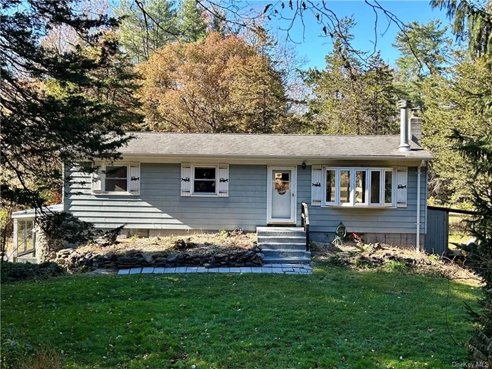 Charming ranch-style home on 4.3 acres, complete with a four-stall horse barn. The property offers a balanced mix of level horse pastures, an open front yard, and borders the scenic Wappinger Creek. Inside, the 3-bedroom ranch features a spacious living room with a striking wood-burning fireplace and a large bay window showcasing views of the front yard. The open-concept dining room flows into the living space and has easy access to the deck through sliding doors. Perfect for grilling or overlooking the pastures, the deck enhances the outdoor living experience. The country-style kitchen boasts sleek black countertops paired with classic white wood cabinetry. The main floor includes a full bath and three generous bedrooms, each with ample closet space. Richly stained hardwood floors add warmth and character throughout. The partially finished lower level expands the living area, complete with an additional kitchen, full bath, and a sunroom ideal for guests or potential rental income.