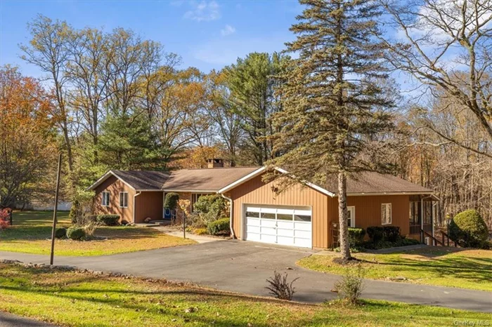 RHINEBECK-Desirable location 5 minutes from Rhinebeck Village center. A quiet and peaceful cul-de-sac setting, this ranch has plentiful natural light with a great flow. The semi-open floor plan brings indoor and outdoor living together, with a separate wing consisting of 3 bedrooms and 2 full updated bathrooms. Beautiful wood floors, a unique stone fireplace, central air conditioning, and a full walkout basement that has interior access. The large deck overlooks the 1.5 acre property, which has sweeping green lawns and is surrounded by mature trees for privacy. An enclosed screened in porch connects the house to the generous two car garage. There&rsquo;s also a stone wall bordering the driveway adding to the curb appeal. As they say location is key, come make this your new home!