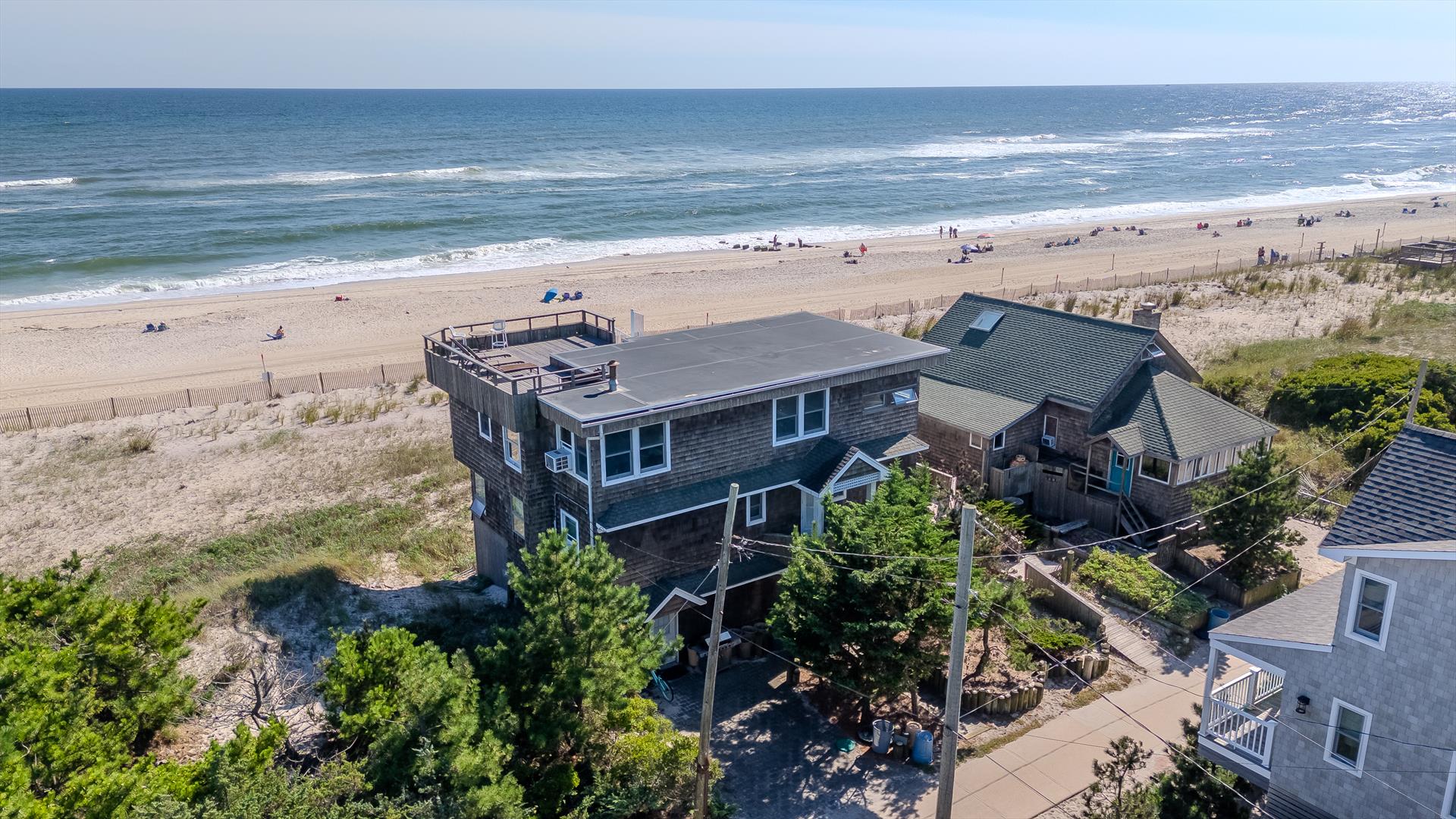 Situated high above the dunes, this spectacular 5 bedroom beachfront home is in the heart of the Village of Ocean Beach.  With breathtaking panoramic views of the Atlantic Ocean, this special property is not to be missed!  Featuring an open concept great room, 3 full bathrooms, and stunning views from every room, this is the home you’ve been waiting for.  On the first floor you will find 4 spacious bedrooms and 2 full bathrooms.  Three levels of ocean-facing decks provide the perfect spot to lounge, whether you prefer the shade or sunshine.  The second floor is comprised of the expansive great room and luxurious master with private en-suite bath and direct deck access.  Head up to the grandfathered in roof deck for breathtaking sweeping bay to ocean views. Ground floor offers incredible storage.  Conveniently located, this home is just a short 7 minute walk to the ferry, restaurants and amenities of downtown Ocean Beach!  Affordable flood insurance, $2,833 per year. Shown by appointment only.