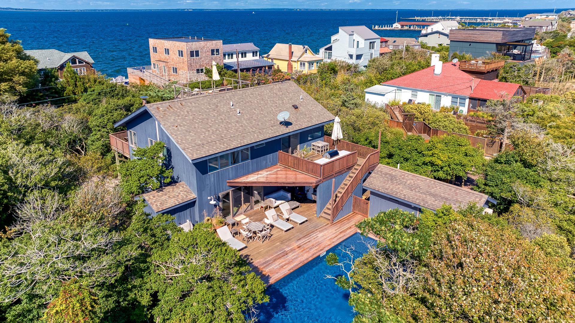 This stunning home with pool and hot tub sits on a massive 125' X 100' lot in highly desirable Ocean Bay Park. With over 2,400 square feet of living space, this is one of Ocean Bay Park's finest homes, boasting 5 bedrooms, 4.5 bathrooms and spacious decks for entertaining. The large second floor great room features soaring cathedral ceilings, bay views, and a wood burning fireplace.  The open and bright chef's kitchen provides tons of storage, a massive island, and top of the line appliances including a Subzero refrigerator and Viking range. The great room opens into a beautiful screened in dining area, allowing the whole second floor to feel as if it is open to the air.  Sun-filled primary bedroom with private ensuite located on second floor.  Head up to the roof deck to enjoy the breathtaking sunsets over the Great South Bay!  A separate grilling deck with built in BBQ is conveniently located just off of the kitchen, and has stairs down to the pool deck for great entertaining flow.  The main pool and deck area are uncommonly large, and are surrounded by lush trees for privacy.  Relax below the trellis, soak in the hot tub or grab a drink at the outdoor bar for your convenience. Just off the pool deck is a spacious first floor den with a built-in desk for an ideal remote working space! Three additional bedrooms and two full bathrooms are also located on the first floor. The separate guest cottage has its own private full bath. This fully air conditioned and heated home will keep you comfortable for the extended season!  This very special home is shown by appointment only!