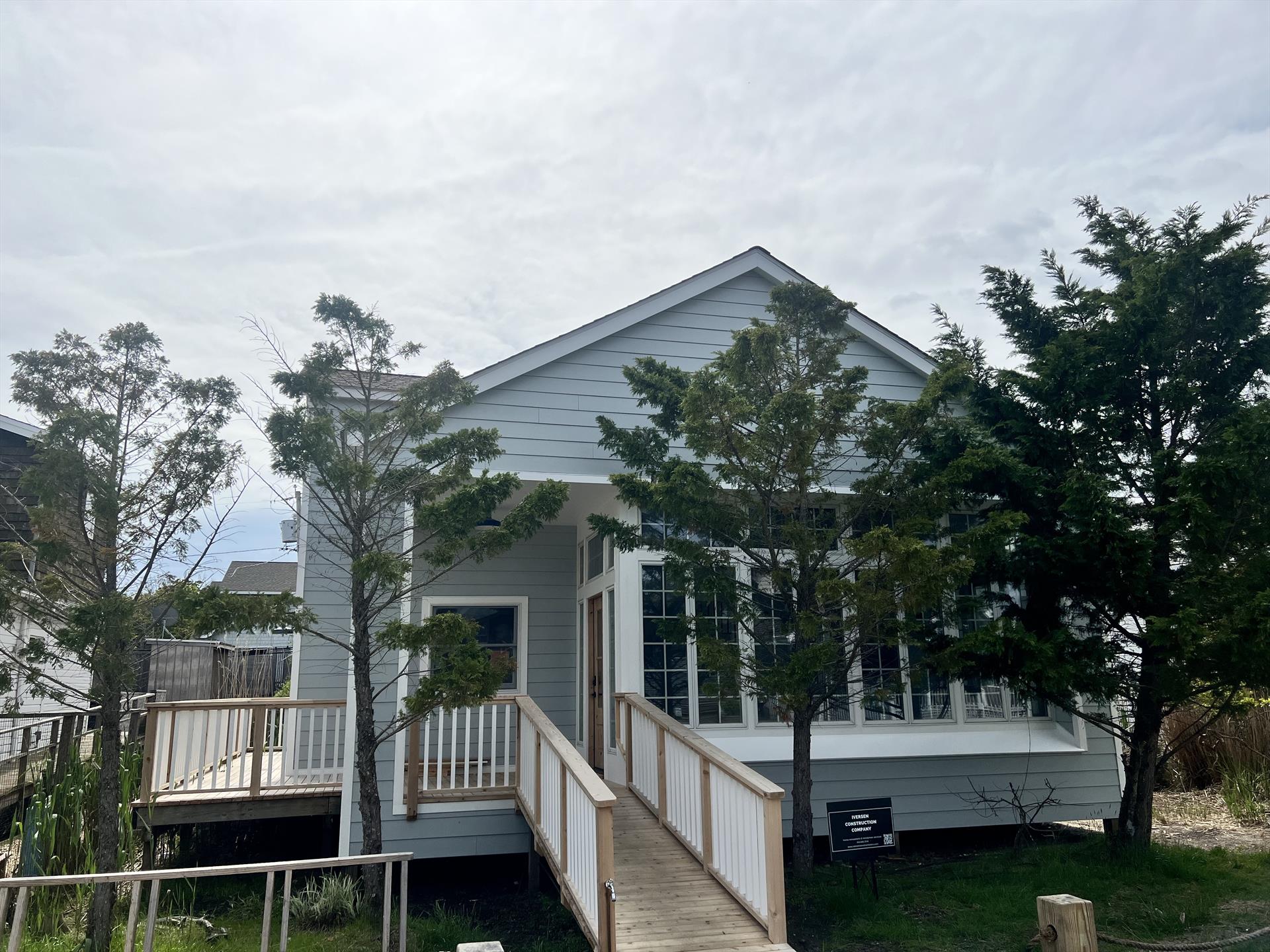 Situated on one of Ocean Beach’s most desirable streets, this completely renovated home is on an oversized 50’X104’ lot.  With 2,020 SF of living space, 4 bedrooms plus an office/flex space, and 3 full bathrooms, 310 Wilmot has plenty of room for your whole crew!  From the covered entry porch to the inviting sunroom, this home’s charms are immediately evident.  Continue on into the spectacular, sun-flooded great room to appreciate the beautiful soaring ceilings and airy, wide open space.  Completely redone from top to bottom, this home features all new roof, siding, decking, HVAC, and flooring.  The all new Hardie plank siding is fire, weather, and insect resistant so you can spend your time at the beach relaxing rather than worrying about the upkeep of your home.  The brand new kitchen has ample storage, gorgeous GE Cafe appliances, an island with breakfast bar, and quartz countertops.  Rounding out the first floor are 3 spacious bedrooms (one of which is a “mini master” with its own en-suite bathroom and room for a King sized bed), laundry, large hall bath, and storage area.  The second floor of the home is dedicated to the enormous primary suite.  With soaring gabled ceilings, walls of closets, spacious en-suite bathroom with dual sinks & custom walk-in shower, and your own private terrace overlooking the pool area, this suite has it all.  The flex space on the second floor is perfect for a gym, office, art studio, or whatever your heart desires.
The outdoor space in this home is just as fabulous as the indoors, with a large back deck featuring a Saltwater swimming pool, outdoor kitchen with grill, sink, and fridge, dining area with built-in banquette, and ample room to lounge.  No Fire Island house would be complete without it’s outdoor shower!  Enjoy your deck in the privacy afforded by 6’ cedar slat privacy fencing around the pool deck.  Shown by appointment only, 310 Wilmot has it all!