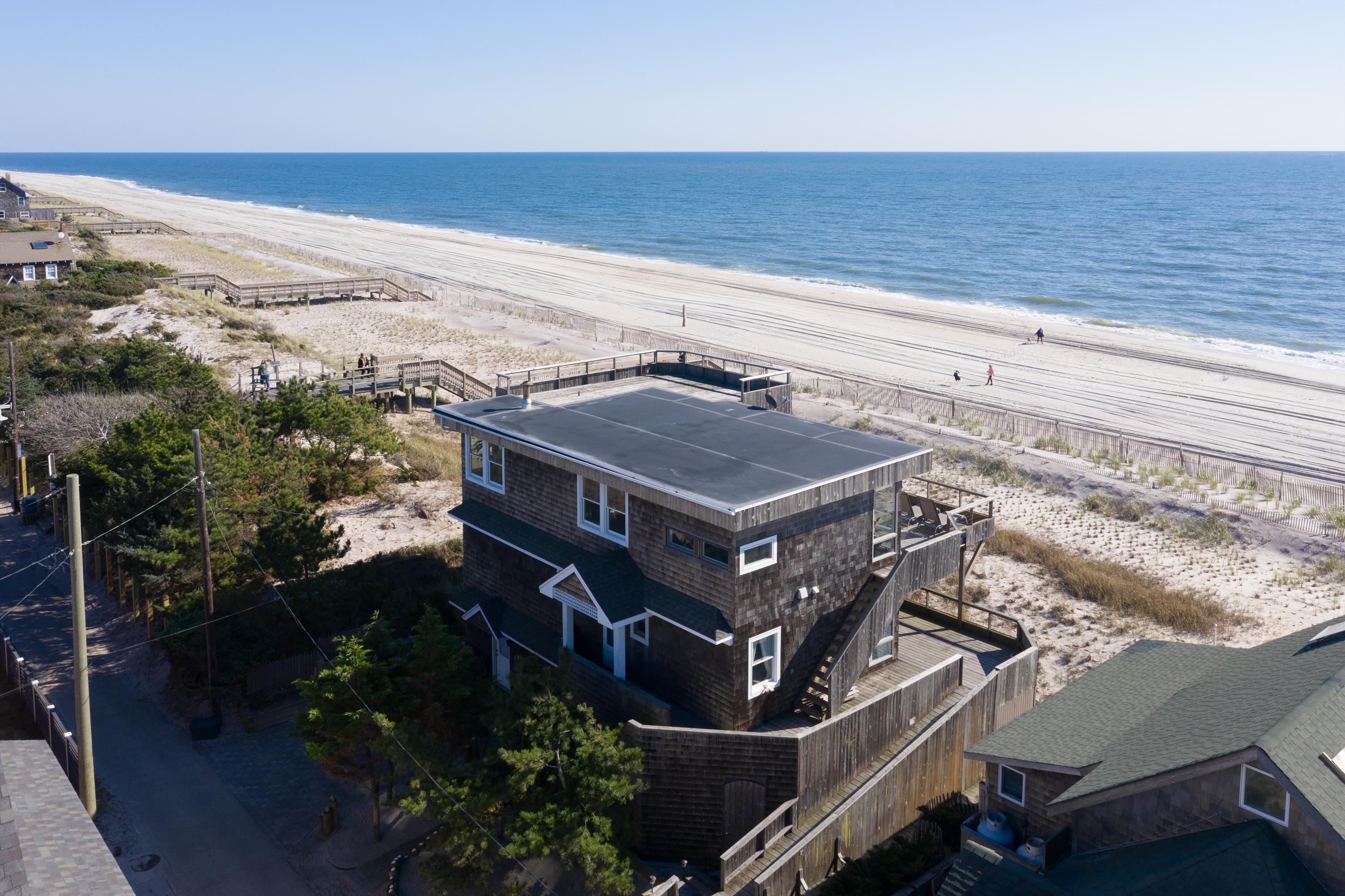 Situated high above the dunes, this spectacular 5 bedroom beachfront home is in the heart of the Village of Ocean Beach.  With breathtaking panoramic views of the Atlantic Ocean, this special property is not to be missed!  Featuring an open concept great room, 3 full bathrooms, and stunning views from every room, this is the home you’ve been waiting for.  On the first floor you will find 4 spacious bedrooms and 2 full bathrooms.  Three levels of ocean-facing decks provide the perfect spot to lounge, whether you prefer the shade or sunshine.  The second floor is comprised of the expansive great room and luxurious master with private en-suite bath and direct deck access.  Head up to the grandfathered in roof deck for breathtaking sweeping bay to ocean views. Ground floor offers incredible storage.  Conveniently located, this home is just a short 7 minute walk to the ferry, restaurants and amenities of downtown Ocean Beach!  Affordable flood insurance, $2,833 per year. Shown by appointment only.