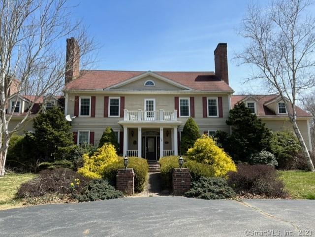 Classic colonial home in rural setting, located less than a 10-minute drive to downtown Mystic. The five-bedroom 5, 500 square foot residence has grace and elegance. The entrance foyer hallway leading to the kitchen passes by a formal dining room, and music room/den with fireplaces. The large kitchen with a dining area, pantry, and center island with two sinks, Wolf stove, and plenty of cabinet space for storage. Off the kitchen is a large sunken living room with nine-foot-high ceilings, attractive built-in shelving with cabinets, flanking a central fireplace. The living room has natural light and two large Palladian doors lead out to the pool and deck. Adjacent to the kitchen, opposite the living-room is a hallway leading to a powder room, closets, three car garage, and a downstairs office/bedroom with access to the pool and deck. From the downstairs entry foyer, an attractive staircase leads to the second-floor landing, with a small balcony overlooking the front lawn. Off the foyer is the 800 square foot primary bedroom suite, with a fireplace, laundry area, two bathrooms, and two large walk-in closets. The opposite side of the house has 3 bedrooms, two with their own bathrooms, and a large office at the end of the hallway. The basement has a laundry/workshop area, and a den with wine storage. Condition issues are present: the roof, swimming pool, and surrounding deck need to be restored. Approved for a 2, 500 square foot guest house.