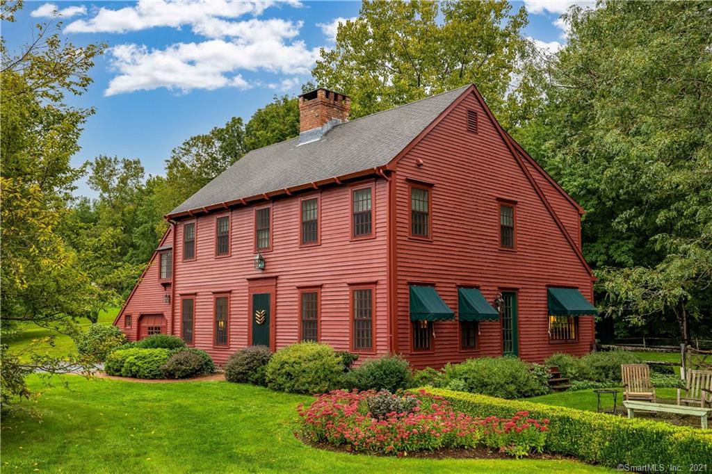 Atop Ridgewood Road is this finely crafted reproduction Saltbox home expressively featured in Country Red accented with Hunter Green awnings. Enter through the formal front door where newly refinished oak hardwood floors spread throughout. Dining and family room with bluestone fireplace flank either side of the home with the open kitchen and library in the rear. The newly remodeled kitchen features Candlelight Cabinetry with custom panels throughout, a 7.5ft center island of hidden conveniences with French Doors that lead to the rebuilt deck. New for '21 appliances include the dbl ovens, microwave and gas stovetop. The library with custom bookshelves has large windows overlooking the side patio letting in southern light with bay window views of the backyard. Living areas feature 3pc custom ceiling moldings with 8in baseboards. Venture upstairs to the master bedroom with remodeled ensuite bath a large walk-in shower, marble countertops and black slate floors.  Three add'l bedrooms and full bath complete the 2nd level. Off the kitchen is the side entrance & mud room that houses the laundry and half bath, with stairs that lead to the large studio/office/rec room over the two car garage. With sunset views, Flanders Woods giving you backyard privacy and only minutes from the antiquing, coffee shops and eateries of historical Woodbury, it is not to be missed.