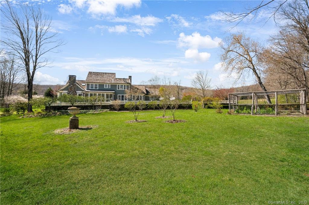 Stunning New England Colonial with superior craftsmanship and the protected land of Flanders Preserve abutting, make this home the perfect place to be. It's raised bed gardens with stone surround, stonewalls, circular driveway, gorgeous gardens and level lawn set it apart. The fully heated and cooled sun room overlooks the perennial gardens, stone terrace and mature trees. The interior spaces include high-end trim & finishing work along with coffered and vaulted ceilings, wideboard oak floors, marble baths and french doors, all which create a rich and sumptuous interior. The Chef's kitchen offers granite counters and stainless Wolf and Miele appliances, a prep island, breakfast nook and opens on to spacious vaulted ceiling family room with fireplace. The main level master is complete with luxurious marble bath, steam shower, raised hearth fireplace and 2 walk in closets. Additionally, 3 fireplaces and a fully heated and cooled sun room which can be used in all seasons round out the first floor. The second level has and easy flow with three bedrooms, one en suite and office/loft space. An attached over sized garage leads to a Mud Room with built-ins and laundry room. A private and magical location, just a few minutes from Historic Woodbury Center and 90 minutes from NYC. Perfection!