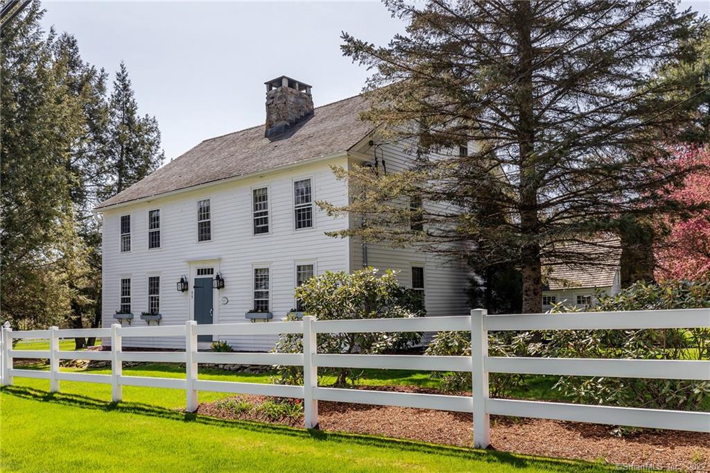 A beautiful vintage estate on 3.6+ level acres with a 4/5 bedroom center chimney Colonial, in ground pool and spa, pool house, 2 story barn and carriage house. Wonderfully preserved, the period details throughout the home include 3 original fireplaces, wide plank floors, Chestnut beams, horizontal and decorative wood paneling, built-ins and hardware. The main floor includes the living room with fireplace and beehive oven, formal dining room with fireplace, Eat-in kitchen, family room with fireplace, cozy library and private office with fireplace. Upstairs you have the primary bedroom with dressing room, built-ins and two full baths. Two bedrooms share the hall bath and third bedroom has its own bath. The laundry is conveniently located on this level. There is a greenhouse on the east side of the home. The inground pool with spa is heated and the pool house includes an outdoor shower, changing room, sitting room with cable, telephone, electricity and water, a cooking room with countertops and sink. The two story barn built ca 1900 has first floor storage,  a second floor rec room and 1 bay carport. The carriage house includes a 1 bay garage with door, second floor storage and an open covered space for additional car parking or lawn equipment. Park-like grounds with professional landscaping includes lush level lawn, perennial gardens, and flowering trees and bushes. Just minutes to the town center and 90 minutes to NYC.