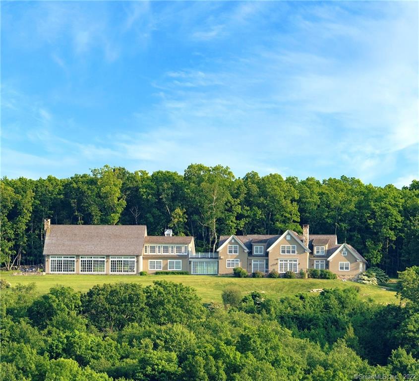 Rarely does such a front row center seat become available! Perched high atop Gunn Hill in New Preston, this extraordinary 22 acre estate has panoramic views of Lake Waramaug & the Hills of Kent and Warren. Its commanding position captures breathtaking sunrises, sunsets, and starry nights. Recently built and lightly used, the classic shingle style residence is spacious indeed - 9, 000 sq ft of living space accessing 1700 sq ft of mahogany deck & blue stone terraces. The park-like grounds are magical, featuring gardens, a 40'x20' heated swimming pool, rolling manicured hills with meandering pathways by ancient stone walls, birch tree forests and remains of an old quarry. A Portico leads to a spacious foyer with a Powder Room and Coat Room nearby and a formal Dining Room featuring a lighted hip ceiling and corner Club door to a butler's pantry with standing bar-sink. The foyer and exquisite stairway open to the spacious Living Room with coffered ceiling, FP, custom cabinetry with window seat. Glass doors open to the enormous terrace. The Primary Bedroom Suite also has a door to the terrace, a seating area, dual dressing rooms and a luxurious spa bathroom with radiant heated marble tile floors. The Cherry paneled Library w/FP and the family Dining/open plan Kitchen have many windows and access to the terrace. The kitchen is a dream with walls of cabinets and windows, a breakfast bar, an island with prep-sink and Sub-Zero and Wolf appliances. SEE ADDENDUM