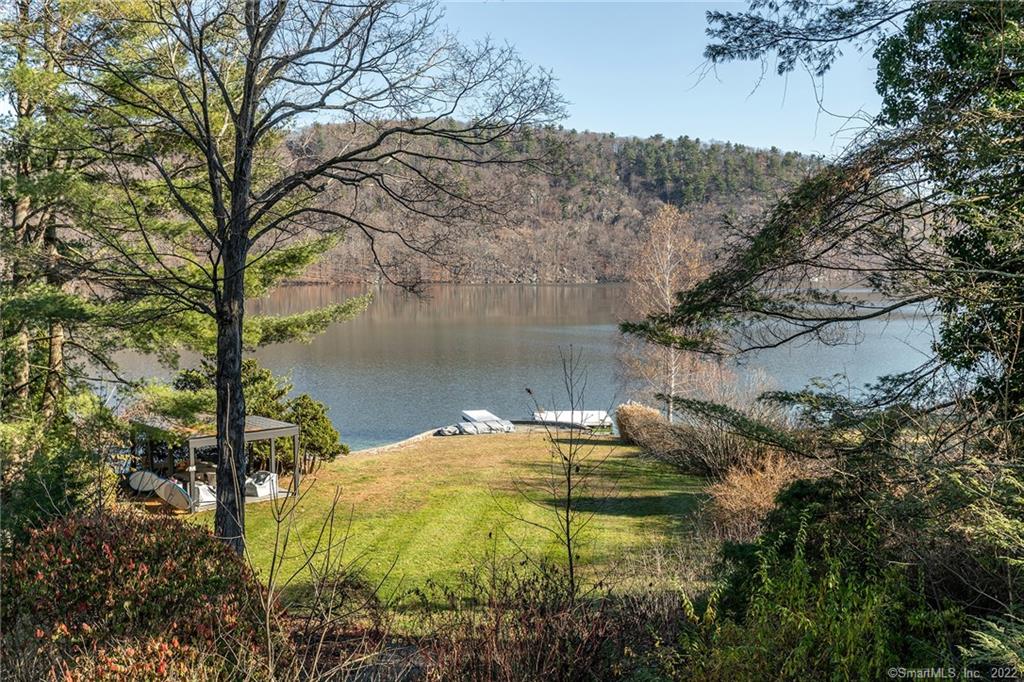 Striking Contemporary designed to enjoy stunning views with direct frontage on Candlewood Lake, CT's largest lake. The open floor plan on the main level encompasses the living/dining area and the modern kitchen with a center island. The lakeside wall is mostly glass with three sets of French doors that open to the expansive stone terraces that span the length of the house and features a large hot tub, seating area and grill. Step down from the terrace to a beautiful lawn thatleads to the dock and lakeside seating and dining area with a pavilion and lighting. There is also a mudroom, wet bar area, full bath, pantry and large laundry room on this level. On the second level are two bedrooms, a full bath and sitting room/den. The master bedroom suite is on the third level and features high ceilings, dressing room, and a spacious bath with soaking tub, twin vanities and separate shower. A sitting room/office is also on this level and is furnished as a 4th bedroom. The landscaped property gently slopes to the lakeshore where there is a large private boat/swimming dock. The home is within the Deer Run Shores Community giving homeowners access to a pool, sandy beach, and clubhouse. Rental Prices $7, 500/month winter; $12, 500 May and October. Already rented for June through Sept. 2023.