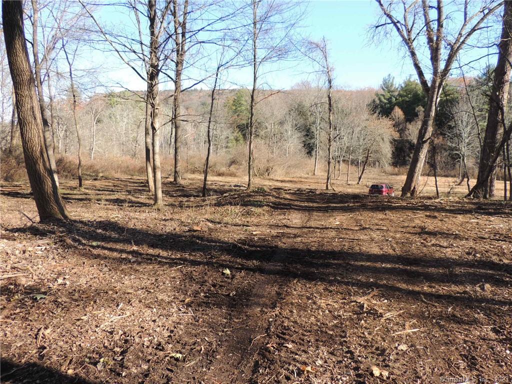 The only substantial building lot near the center of the Village of Salisbury; Reached thru a private shared limited access roadway from Route 44, this lot has gladed woods, a flat, sometimes flooded, open lot along Moore Brook, an attractive view to a nearby mountainside, and is set along the walking-bike rail trail just a few minutes walk from the center of town. It offers excellent privacy, away from the highway, and is an ideal alternative to condominium alternatives as you can build the exact village home that you want right in the middle of Salisbury. Town water and sewer hookups are accessible, or possibly you can put in a well and septic if you might want that instead. An undefined R.O.W. exists through the property to access an adjacent lot, which might also be available for purchase. An environmental review of the property might be recommended, though it has been mostly cleaned, and partially cleared. Two of the 4 owners hold real estate licenses.