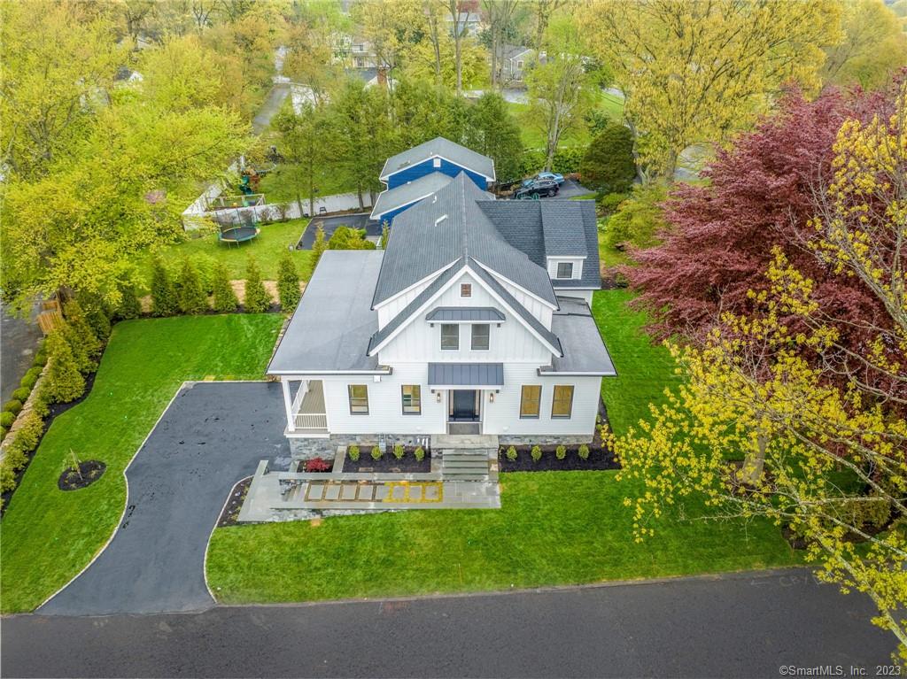 In the esteemed N Mianus School district on the Riverside border of Cos Cob, find a luxurious, turn-key modern farmhouse spanning 4200 sq ft. Built for low maintenance, this home balances seclusion with generous family & entertainment spaces. Mature landscaping, Bluestone & Getty Grey masonry frame a 10' mahogany door. Inside, a gourmet kitchen links to a spacious fam. room & adaptable spaces for a home office/yoga studio. Enjoy proximity to train & fine dining.The expansive 600 sq ft deck creates an outdoor sanctuary. The home boasts 2 primary & 4 add'l bdrms, each with en-suite baths & lg walk-in closets. Featuring Porcelanosa tiles, California Faucets, Dacor appls, an Enigma Ra Quartz kitchen & a Calacatta Sky marble gas fireplace, this home includes a 1 yr builder warranty & pub utils.