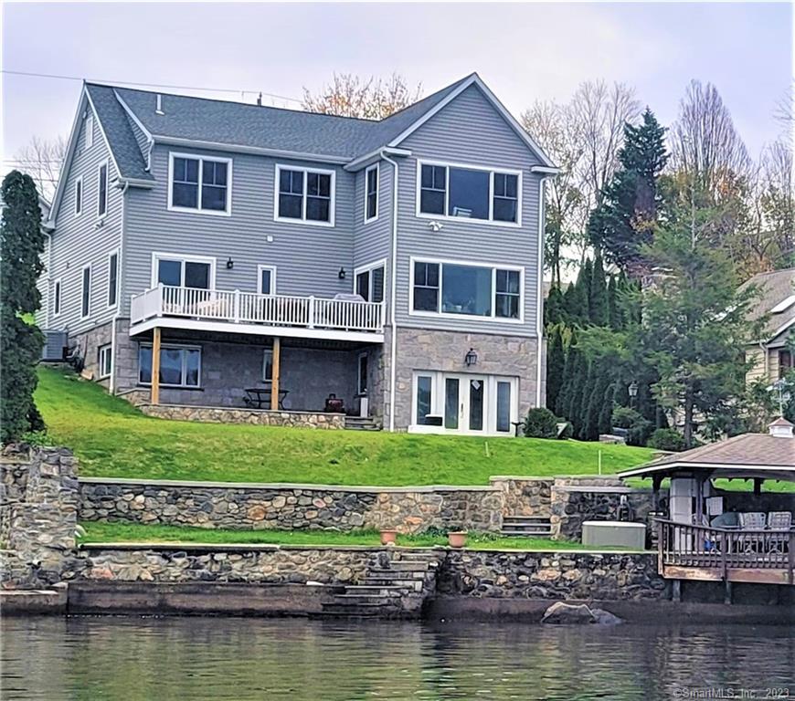 Completed new construction with prime Western exposure on Candlewood Lake. Enjoy spectacular views from the moment you walk in the door. Built-in 2019 with no detail spared, the home features a well-equipped chef's kitchen with an oversized island & Thermador appliances. The gas fireplace in the family room is flanked by custom built-in cabinetry & the 9' ceilings feature custom beams. A deck off the back of the house offers more big views & a perfect space for relaxing. The main level boasts a primary bedroom w/custom walk-in closets & a luxurious, en suite bath with Carrara marble. The 2nd level features another spacious primary bedroom with panoramic views. This dreamy room includes a spa-like bathroom, custom vanity, oversized shower & jetted tub. Two large custom walk-in closets & an adjoining room can be used for storage or as an office. Two more bedrooms, a full Jack & Jill style bathroom with custom finishes, and a loft sitting area for taking in the views. The LL features another full kitchen, perfect for entertaining, a second fireplace, & a full bath, plus ample living space. The home has a waterfront cabana space with its original stone grill & oven, plus a deck over the water & a new composite boat dock & catwalk. Experience lake life in this one-of-a-kind home. Located in Candlewood Shores, walk to the beach community amenities. Close to all shopping, & schools Ideal commuter location. Stunning sunsets. Updated engineered septic in 2022. New Walk Ways & patios.