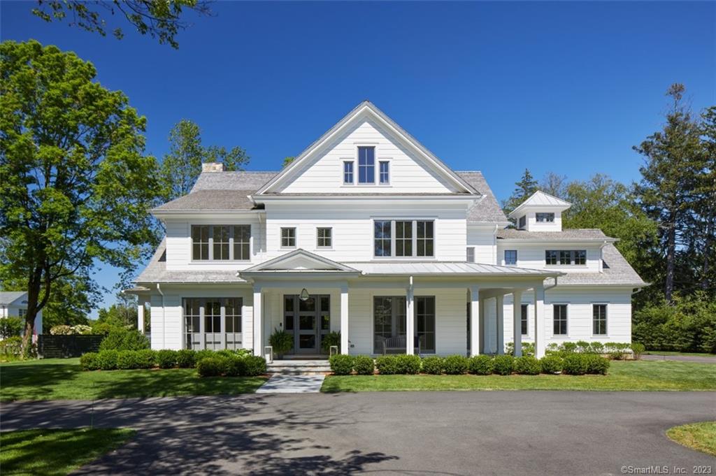 Located on prestigious Oenoke Ridge Road in the heart of New Canaan, this truly spectacular modern farmhouse provides every high-end amenity with stunning designer finishes and the highest level of craftsmanship for your dream summer experience. Just steps from the Nature Center, walking trails and a short walk to the center of Town with amazing restaurants, shops and theater, this location could not be better. Maintained to perfection, this airy open concept home offers wonderful flow from the welcoming wrap around porch to the foyer and living room with a gas fireplace, large chef's kitchen with a huge island and butler's pantry and bar, adjacent to the large family room also with a fireplace and French doors leading to the private, beautifully landscaped backyard with a Gunite pool and spa for your enjoyment. The large patio has plenty of comfortable seating and the outdoor kitchen is perfect for alfresco dining. The Primary Suite has a cathedral ceiling, spa bathroom and walk-in closet all overlooking the pool and gorgeous grounds. Four additional ensuite bedrooms complete this level. The lower level has a large game room, full gym and the special bonus feature is the barn outfitted with a basketball court. The flat grassy backyard is the perfect backdrop for croquet! Truly a special offering.
