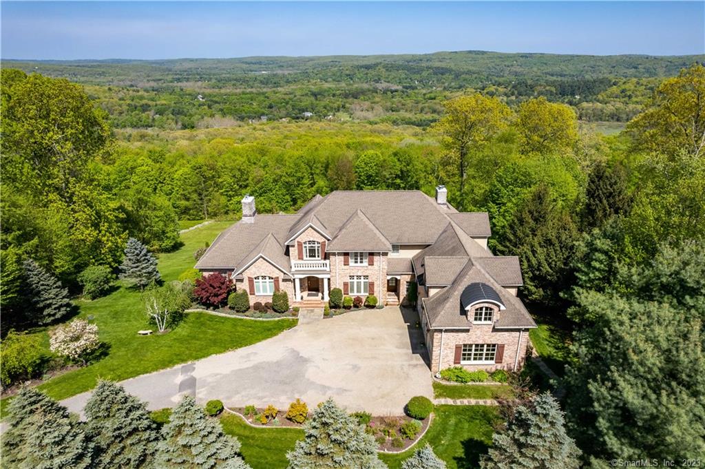 Built of the finest materials by Eric Strachan Builders this Georgian Colonial sits atop the estate section of Owl Ridge with stunning 20-mile views. Upon entry the double height foyer is flanked by the formal living and dining rooms. The grand chef's kitchen in the heart of the home features granite counters, abundant cabinets, Wolf range and wall ovens, Subzero refrigerator with two add'l refrigerated drawers housed in the island. A wall of windows and corner wall mounted gas fireplace frame the eat-in-kitchen area. Off the kitchen is the family room accented with a coffered ceiling and gas log fireplace. A set of dbl doors off the foyer lead you to the main floor primary suite with marble surround gas fireplace, a tray ceiling overhead and ensuite bathroom with separate water closet, shower and hydro tub. Natural light accents the custom cabinetry that lines the large L shaped walk-in closet. The large office and den combo, laundry and full bath finish out the main floor. Upstairs houses three large bedrooms, one ensuite the others share a jack-n-jill bathroom. The large bonus room over the garage with roughed-in bath is perfect for an au pair quarters or additional play room. The lower level features a great room centered by a gas fireplace, game room, wine cellar, full bath and possible sauna location. Close to hiking trails and mins from the shops and restaurants of Woodbury, a 90? drive from NYC.