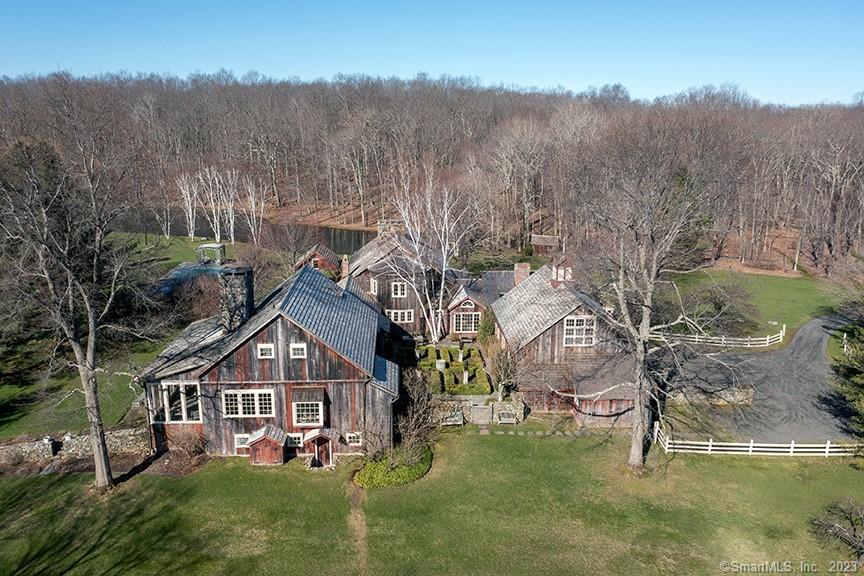 Unsurpassed Washington, CT Estate on 104 magical acres featuring open meadows, stone walls, mature garden, ponds & distant views situated off a scenic dirt road. The main house complex is a series of converted antique barns with exposed posts & beams throughout. The centerpiece of the main house is the stunning living room, which is an antique barn with vaulted ceiling, floor to ceiling wood burning fireplace & French doors overlooking one of the ponds. Dining room with fireplace. Eat-in country kitchen. Four en-suite bedrooms with bathrooms. Screened (glass in winter) porch with fireplace. Stone terrace with dining pavilion and outdoor fireplace. Swimming pool. 3-car attached garage. Separate two-bedroom guest house. While proximate to the villages of Washington Depot & New Preston, the property is surrounded by land trust offering ultimate privacy and enjoys only the sounds of nature. Long driveway. 5 deeded parcels with no easements. Property has been featured in Architectural Digest. Rare.