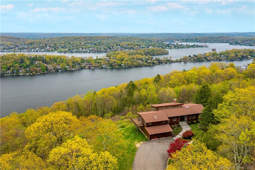 Create your own mini compound overlooking Candlewood Lake with East, North and South views. Fall in love with the breathtaking vistas at 4 North Star Drive combined with Lot #2, this unique offering allows for many options. A fabulous home to entertain in, both inside and out, with expansive decking to enjoy Candlewood Lake's beauty. When you open the front double doors, nature's beautiful streams into the house with views of Candlewood Lake, distant mountains, and in the evening, starlit skies and twinkling lights across the lake. The center of the home is where lifetime memories are made in the great room with soaring ceilings lined with wood, floor-to-ceiling stone fireplace, dining room space and opens to the kitchen with breakfast nook. All surrounded by walls of sliders and windows, decking and incredible views. On the south side, there is a half bath, the den/family room/office, laundry, full bath and two spacious bedrooms, one with sliders to the deck. On the north side, a few steps lead to the master bedroom with sliders to a private deck, walls of windows to enjoy the view, a private full bath and walk-in-closet with built-in's. The walkout, finished lower level rec room is heated, has sliders to the beautiful yard and lots of storage, too. Move-in-ready, well maintained and with a full house generator. Lot #2 is 1.29 acres, totaling 5.14 acres. Bring your dreams and make this your own! Welcome Home.