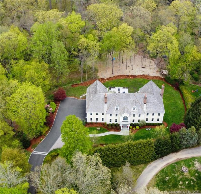 A hidden gem down a long, private driveway, nestled amongst gorgeous landscaping & plantings, awaits. This breathtaking estate is set on 2.31 majestic acres & features 4 levels of spacious living w/over 7000 sf. The current homeowner spared no expense w/upgrades totaling over $290, 000 of new Andersen windows throughout, entire exterior/interior freshly painted, new oversize patio, new sprinkler system, extensive landscaping including the removal of 15 trees, new washer/dryer & dishwasher, & the list goes on. Two story entrance w/soaring ceiling is a fabulous representation of the true architectural brilliance. The 1st level hosts a thoughtfully designed & open floor plan, extensive millwork, over 9' ceilings, hardwood floors, & 3 fireplaces. The eat-in kitchen hosts a large island, high end appliances, oversize pantry & french doors that lead to expansive deck. Entertaining is a delight w/options in either your family room w/coffered ceiling & cozy fireplace or living room w/additional fireplace. Formal dining room w/tray ceiling, library & 4 car garage complete the 1st level. The 2nd level showcases the primary suite w/walk-in closet, 2 more closets, & luxurious bath plus 4 bedrooms & office. Upper level bonus room & finished walk-out offers amazing living options. Outside entertaining is a delight w/privacy, serenity & designed for pure relaxation. You feel like you are on vacation in a country setting while remaining close to all amenities of Fairfield & Westport.