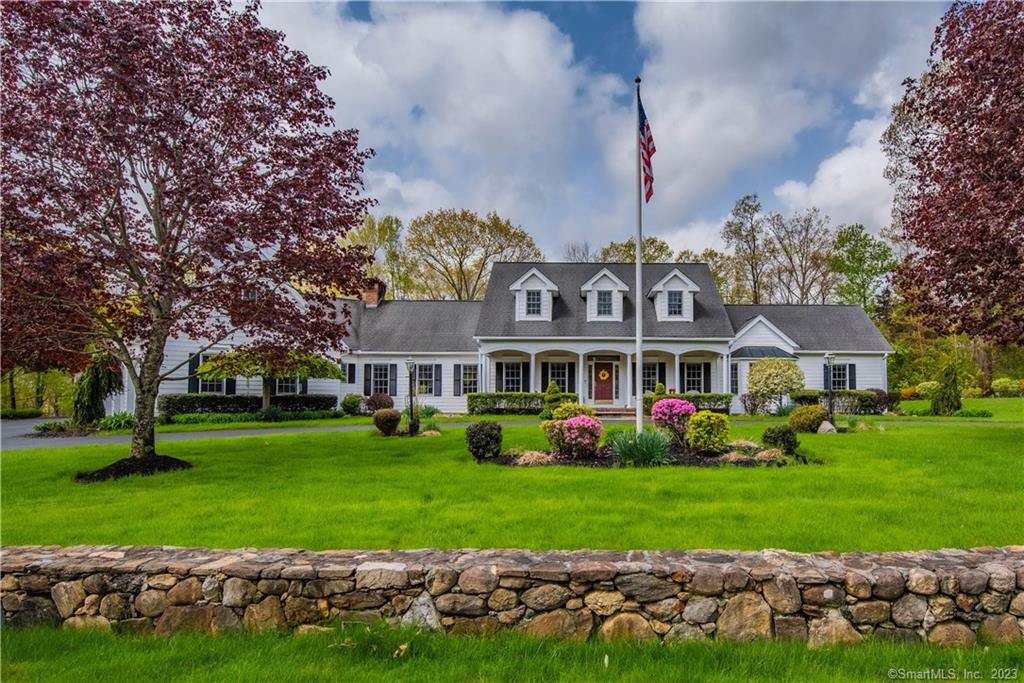 Welcome home to this meticulously maintained expanded cape in an upscale Woodbury neighborhood. A circular driveway leads you to a beautiful blue stone covered front porch. Once you enter, you'll find a formal living room and formal dining room on either side of the foyer. In the custom kitchen you'll find a gas cooktop, integrated appliances, center island and peninsula. The kitchen opens nicely to the family room and sunroom. The spacious family room has cathedral ceilings and a floor-to-ceiling fieldstone gas fireplace. The light filled sunroom can be another dining area or sitting area offering access to the back patio. There's a beautiful office with french doors, mahogany paneling and built-in bookshelves. The main level primary suite has tray ceilings, walk-in closet and bath with an oversized shower and soaking tub. On the second floor are two generous sized bedrooms each with a sitting area. This park-like property has beautiful stone walls, an irrigation system and a koi pond with a waterfall. Possibilities are endless with a huge unfinished basement and an additional unfinished room above the three car garage. Upgrades include transom windows, wainscoting panels, driveway alarm and irrigation system with separate well.