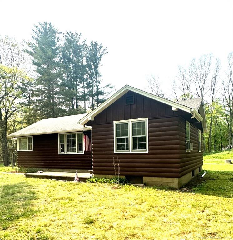 Welcome to this two-bed, one bath ranch-style home, nestled on an acre of land surrounded by the serene beauty of nature. The exterior of the home is adorned with charming log siding, giving it a rustic and inviting feel. Step inside to find a warm and inviting living space with a beautiful hearthstone wood burning stove, perfect for cozy evenings spent indoors. The living room also features wood beams, adding to the charm and character of the space. The interior is designed to complement the outdoors, with natural wood accents, oak flooring, earthy tones, and plenty of natural light. The semi-open layout of the kitchen creates a sense of connectivity with the rest of the home. The white Shaker cabinets are paired well with the light-colored vinyl flooring, creating a bright and airy feel. Step out onto the 10x10 enclosed porch, perfect for enjoying the natural beauty. Relax and watch the turkeys and deer grazing in the yard or enjoy the peacefulness and tranquility of the setting. The property includes a 12x22 gambrel roof garage, providing plenty of space for storage or to park a vehicle. An 8x8 tool shed provides additional storage space for all your outdoor equipment. Located in an area known for its natural beauty, this charming ranch-style home offers easy access to kayaking, hiking, and skiing, making it the perfect retreat for outdoor enthusiasts. Whether you're looking for a quiet place to unwind or an active lifestyle, this home offers the perfect balance of both.